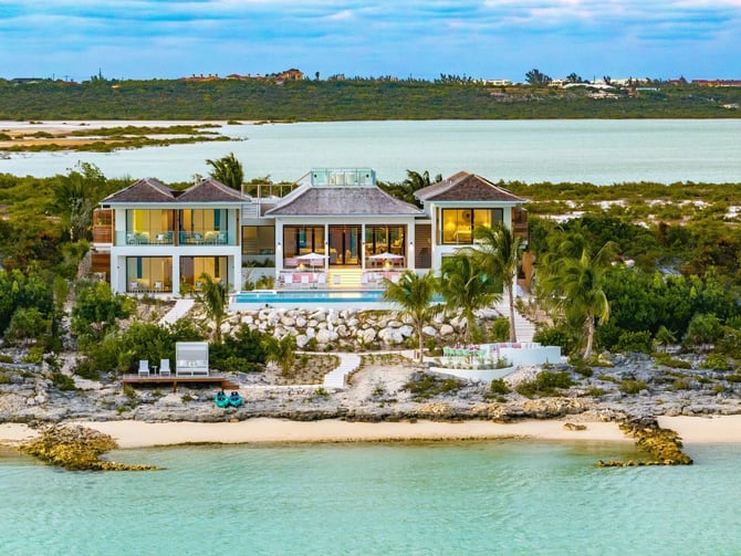 Vista aérea de una villa en una península privada con aguas turquesas, Turks & Caicos